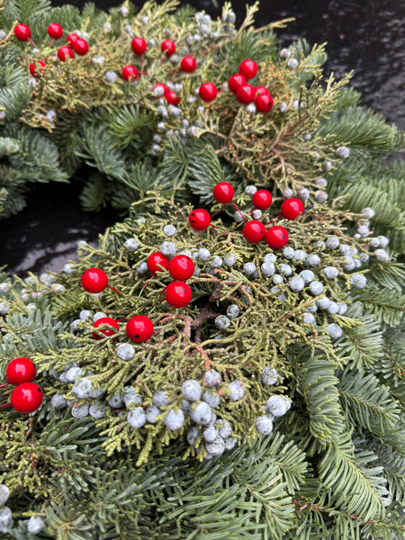 Fir and juniper berry fresh Christmas wreath with noble fir and red berries